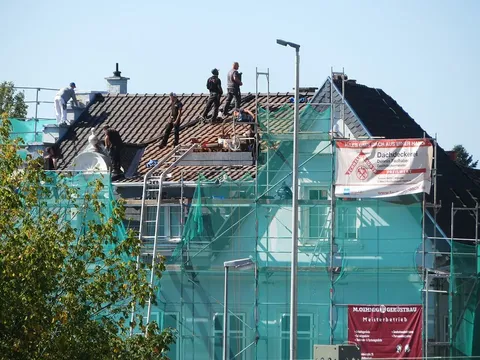 Couvreurs au travail sur une toiture échafaudée