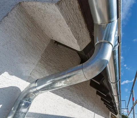Descente d'eaux pluviales en zinc le long d'une façade